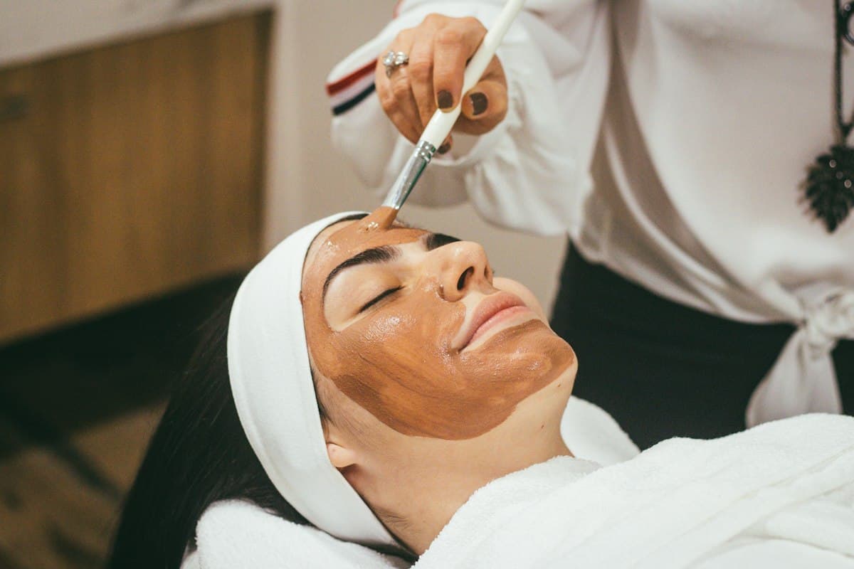Paciente relaxada recebendo aplicação de máscara facial