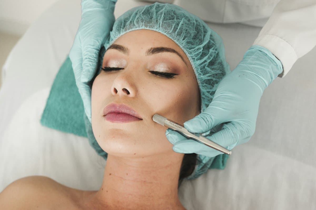 Procedimento facial realizado com luvas, em ambiente clínico